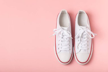 Beyaz ayakkabılar, parlak renkli arka planda spor ayakkabılar. Tek cinsiyetli spor ayakkabıları. Üst Manzara. Mesaj için yer var. Uzayı kopyala. Güzel spor ayakkabılar. Moda ayakkabılar