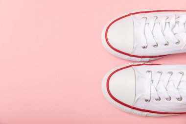 Beyaz ayakkabılar, parlak renkli arka planda spor ayakkabılar. Tek cinsiyetli spor ayakkabıları. Üst Manzara. Mesaj için yer var. Uzayı kopyala. Güzel spor ayakkabılar. Moda ayakkabılar