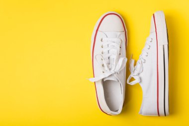 Beyaz ayakkabılar, parlak renkli arka planda spor ayakkabılar. Tek cinsiyetli spor ayakkabıları. Üst Manzara. Mesaj için yer var. Uzayı kopyala. Güzel spor ayakkabılar. Moda ayakkabılar