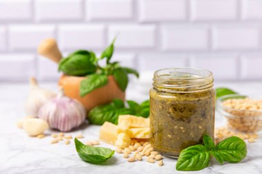 Pesto. Ahşap kaplamalı İtalyan fesleğen sosu. Pesto sosu içeriği: taze fesleğen, çam fıstığı, parmesan peyniri ve zeytinyağı. Metin için boşluk. Boşluğu kopyala.