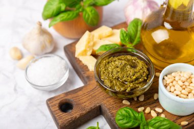 Pesto. Ahşap kaplamalı İtalyan fesleğen sosu. Pesto sosu içeriği: taze fesleğen, çam fıstığı, parmesan peyniri ve zeytinyağı. Metin için boşluk. Boşluğu kopyala.