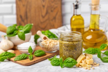 Pesto. Ahşap kaplamalı İtalyan fesleğen sosu. Pesto sosu içeriği: taze fesleğen, çam fıstığı, parmesan peyniri ve zeytinyağı. Metin için boşluk. Boşluğu kopyala.