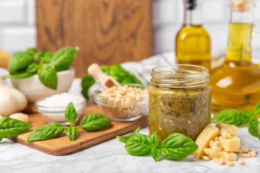 Pesto. Ahşap kaplamalı İtalyan fesleğen sosu. Pesto sosu içeriği: taze fesleğen, çam fıstığı, parmesan peyniri ve zeytinyağı. Metin için boşluk. Boşluğu kopyala.
