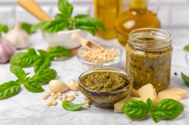 Pesto. Ahşap kaplamalı İtalyan fesleğen sosu. Pesto sosu içeriği: taze fesleğen, çam fıstığı, parmesan peyniri ve zeytinyağı. Metin için boşluk. Boşluğu kopyala.