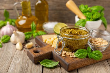 Pesto. Ahşap kaplamalı İtalyan fesleğen sosu. Pesto sosu içeriği: taze fesleğen, çam fıstığı, parmesan peyniri ve zeytinyağı. Metin için boşluk. Boşluğu kopyala.