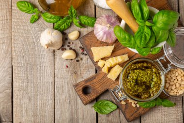 Pesto. Ahşap kaplamalı İtalyan fesleğen sosu. Pesto sosu içeriği: taze fesleğen, çam fıstığı, parmesan peyniri ve zeytinyağı. Metin için boşluk. Boşluğu kopyala.
