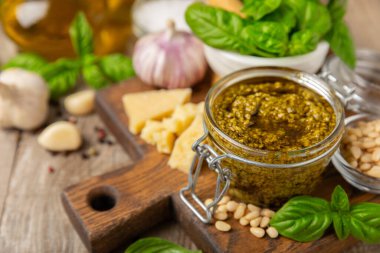 Pesto. Ahşap kaplamalı İtalyan fesleğen sosu. Pesto sosu içeriği: taze fesleğen, çam fıstığı, parmesan peyniri ve zeytinyağı. Metin için boşluk. Boşluğu kopyala.