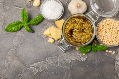 Pesto. Ahşap kaplamalı İtalyan fesleğen sosu. Pesto sosu içeriği: taze fesleğen, çam fıstığı, parmesan peyniri ve zeytinyağı. Metin için boşluk. Boşluğu kopyala.