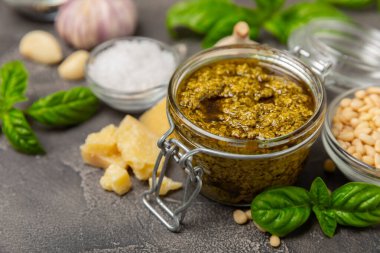 Pesto. Ahşap kaplamalı İtalyan fesleğen sosu. Pesto sosu içeriği: taze fesleğen, çam fıstığı, parmesan peyniri ve zeytinyağı. Metin için boşluk. Boşluğu kopyala.