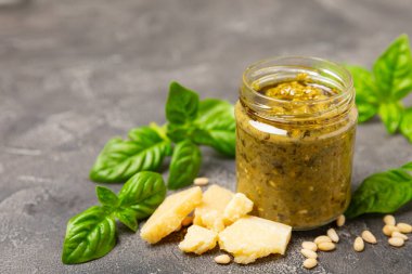 Pesto. Ahşap kaplamalı İtalyan fesleğen sosu. Pesto sosu içeriği: taze fesleğen, çam fıstığı, parmesan peyniri ve zeytinyağı. Metin için boşluk. Boşluğu kopyala.