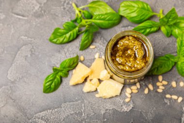 Pesto. Ahşap kaplamalı İtalyan fesleğen sosu. Pesto sosu içeriği: taze fesleğen, çam fıstığı, parmesan peyniri ve zeytinyağı. Metin için boşluk. Boşluğu kopyala.