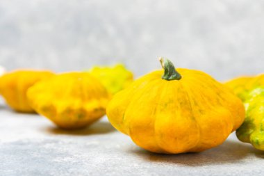 Dokulu mutfak masasında patypan kabağı. Kabak. Arka planda taze organik pattypan kabakları. Vejetaryen. Çiftçi Pazarı. Patisson. Mesaj için yer var. Boşluğu kopyala.