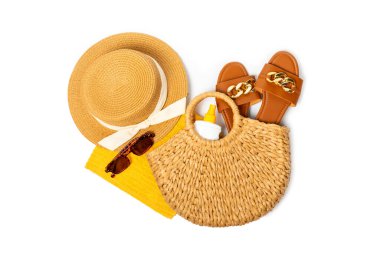 Plaj aksesuarları. Şapkalı plaj çantası, plaj havlusu, güneş gözlüğü, krem ve beyaz arka planda izole edilmiş sandaletler. Tropik tatil konsepti. Yaz haftasonu. Düz yatıyordu. Mesaj için yer var. Boşluğu kopyala