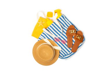 Plaj aksesuarları. Şapkalı plaj çantası, plaj havlusu, güneş gözlüğü, krem ve beyaz arka planda izole edilmiş sandaletler. Tropik tatil konsepti. Yaz haftasonu. Düz yatıyordu. Mesaj için yer var. Boşluğu kopyala