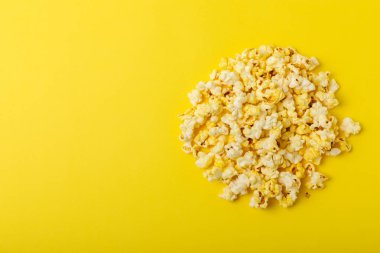 Parlak renkli arka planda tuzlu patlamış mısır. Sinema ve eğlence anlayışı. Patlamış mısırla film gecesi. Lezzetli aperatif, atıştırmalık. Mesaj için yer, fotokopi alanı. Pankart