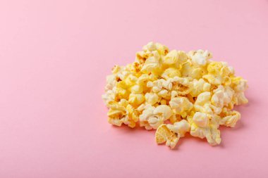 Parlak renkli arka planda tuzlu patlamış mısır. Sinema ve eğlence anlayışı. Patlamış mısırla film gecesi. Lezzetli aperatif, atıştırmalık. Mesaj için yer, fotokopi alanı. Pankart