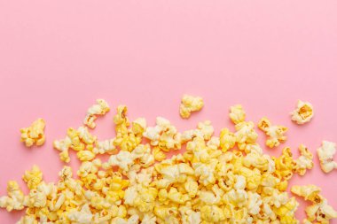 Parlak renkli arka planda tuzlu patlamış mısır. Sinema ve eğlence anlayışı. Patlamış mısırla film gecesi. Lezzetli aperatif, atıştırmalık. Mesaj için yer, fotokopi alanı. Pankart