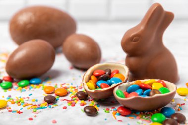 Arka planda paskalya çikolatalı yumurtası. Paskalya kutlaması. Paskalya çikolatalı tavşan. Çikolatalı tatlı yumurta. Şekerler ahşap masanın üzerinde. Mesaj için boşluk. Boşluğu kopyala. Hediye. Pankart.