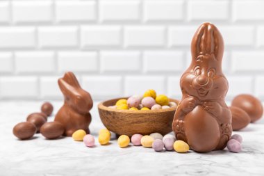 Arka planda paskalya çikolatalı yumurtası. Paskalya kutlaması. Paskalya çikolatalı tavşan. Çikolatalı tatlı yumurta. Şekerler ahşap masanın üzerinde. Mesaj için boşluk. Boşluğu kopyala. Hediye. Pankart.