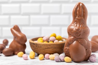 Arka planda paskalya çikolatalı yumurtası. Paskalya kutlaması. Paskalya çikolatalı tavşan. Çikolatalı tatlı yumurta. Şekerler ahşap masanın üzerinde. Mesaj için boşluk. Boşluğu kopyala. Hediye. Pankart.