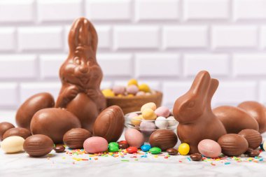 Arka planda paskalya çikolatalı yumurtası. Paskalya kutlaması. Paskalya çikolatalı tavşan. Çikolatalı tatlı yumurta. Şekerler ahşap masanın üzerinde. Mesaj için boşluk. Boşluğu kopyala. Hediye. Pankart.