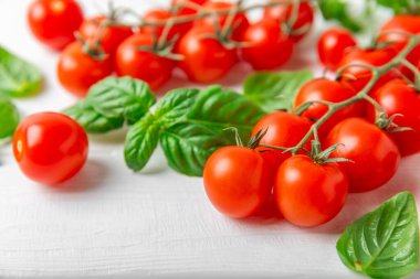 Taze vişneli domates ve dokulu taze yeşil fesleğen. Domates sosu. Vejetaryen. Salata için malzemeler. Organik yiyecekler. Mesaj için yer. Boşluğu kopyala.