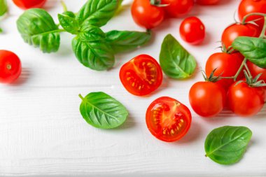 Taze vişneli domates ve dokulu taze yeşil fesleğen. Domates sosu. Vejetaryen. Salata için malzemeler. Organik yiyecekler. Mesaj için yer. Boşluğu kopyala.