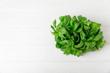 Ahşap kaplamalı yeşil fesleğen yaprakları. Mutfak otları, baharatlar. Taze yeşil organik fesleğen. Vejetaryen. Salata için yeşillik. Mesaj için yer. Boşluğu kopyala.