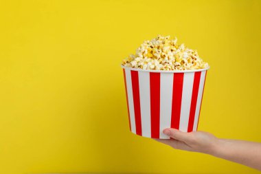 Patlamış mısır kutusu. Renkli arka planda kırmızı ve beyaz çizgili patlamış mısır kovaları. Sinema ve eğlence anlayışı. Patlamış mısırla film gecesi. Lezzetli aperatif, aperatif. Metin için yer.