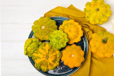 Dokulu mutfak masasında patypan kabağı. Kabak. Arka planda taze organik pattypan kabakları. Vejetaryen. Çiftçi Pazarı. Patisson. Mesaj için yer var. Boşluğu kopyala.