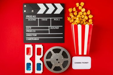 Kova içinde lezzetli karamelli patlamış mısır ve sinema biletleri, film alkışları ve kırmızı arka planda 3 boyutlu gözlüklü soğuk kola içecekleri. Sinema konsepti. Film izliyorum..