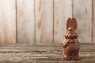 Arka planda paskalya çikolatalı yumurtası. Paskalya kutlaması. Paskalya çikolatalı tavşan. Çikolatalı tatlı yumurta. Şekerler ahşap masanın üzerinde. Mesaj için boşluk. Boşluğu kopyala. Hediye. Pankart.