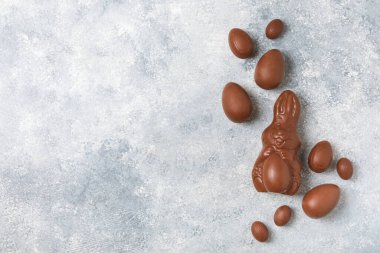 Arka planda paskalya çikolatalı yumurtası. Paskalya kutlaması. Paskalya çikolatalı tavşan. Çikolatalı tatlı yumurta. Şekerler ahşap masanın üzerinde. Mesaj için boşluk. Boşluğu kopyala. Hediye. Pankart.