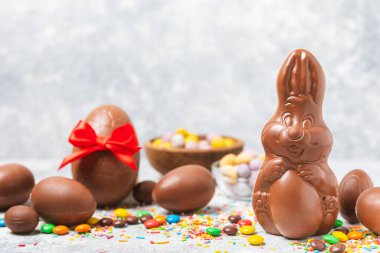 Arka planda paskalya çikolatalı yumurtası. Paskalya kutlaması. Paskalya çikolatalı tavşan. Çikolatalı tatlı yumurta. Şekerler ahşap masanın üzerinde. Mesaj için boşluk. Boşluğu kopyala. Hediye. Pankart.
