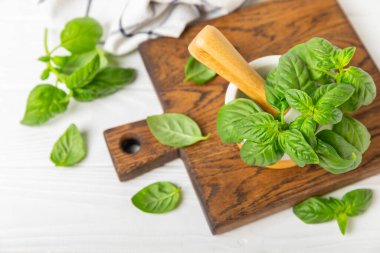 Ahşap kaplamalı havanda taze yeşil fesleğen. Organik baharatlar ve bitkiler. Vejetaryen. Taze mutfak bitkileri. Fesleğen taze fesleğen havan ve kabuklu pesto 'ya dönüştürülüyor. Boşluğu kopyala. Metin için yer