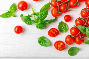 Taze vişneli domates ve dokulu taze yeşil fesleğen. Domates sosu. Vejetaryen. Salata için malzemeler. Organik yiyecekler. Mesaj için yer. Boşluğu kopyala.