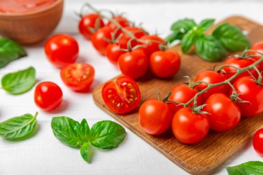 Taze vişneli domates ve dokulu taze yeşil fesleğen. Domates sosu. Vejetaryen. Salata için malzemeler. Organik yiyecekler. Mesaj için yer. Boşluğu kopyala.