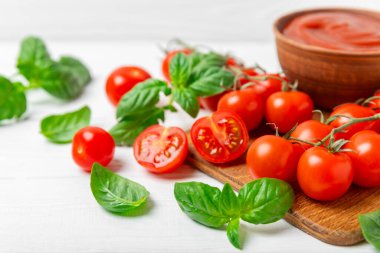 Taze vişneli domates ve dokulu taze yeşil fesleğen. Domates sosu. Vejetaryen. Salata için malzemeler. Organik yiyecekler. Mesaj için yer. Boşluğu kopyala.