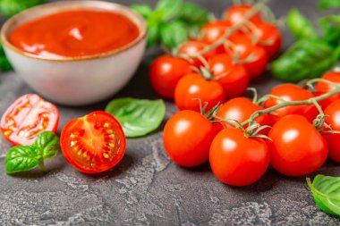 Taze vişneli domates ve dokulu taze yeşil fesleğen. Domates sosu. Vejetaryen. Salata için malzemeler. Organik yiyecekler. Mesaj için yer. Boşluğu kopyala.