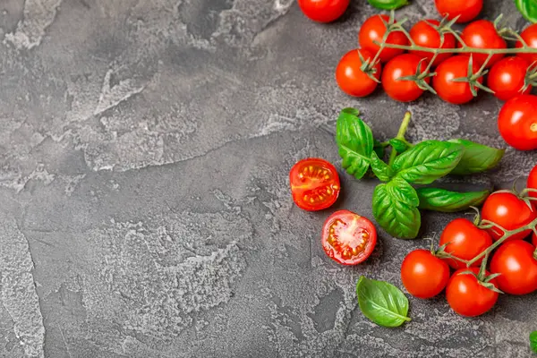 Taze vişneli domates ve dokulu taze yeşil fesleğen. Domates sosu. Vejetaryen. Salata için malzemeler. Organik yiyecekler. Mesaj için yer. Boşluğu kopyala.