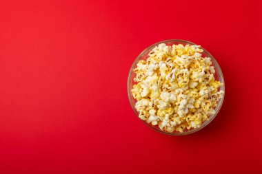 Parlak renkli arka planda tuzlu patlamış mısır. Sinema ve eğlence anlayışı. Patlamış mısırla film gecesi. Lezzetli aperatif, atıştırmalık. Mesaj için yer, fotokopi alanı. Pankart