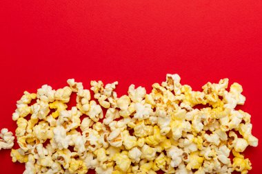 Parlak renkli arka planda tuzlu patlamış mısır. Sinema ve eğlence anlayışı. Patlamış mısırla film gecesi. Lezzetli aperatif, atıştırmalık. Mesaj için yer, fotokopi alanı. Pankart