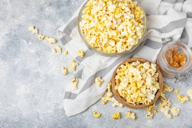 Parlak renkli arka planda tuzlu patlamış mısır. Sinema ve eğlence anlayışı. Patlamış mısırla film gecesi. Lezzetli aperatif, atıştırmalık. Mesaj için yer, fotokopi alanı. Pankart