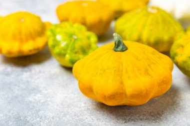 Dokulu mutfak masasında patypan kabağı. Kabak. Arka planda taze organik pattypan kabakları. Vejetaryen. Çiftçi Pazarı. Patisson. Mesaj için yer var. Boşluğu kopyala.