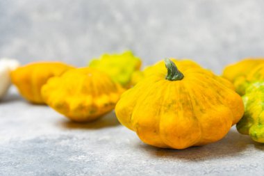 Dokulu mutfak masasında patypan kabağı. Kabak. Arka planda taze organik pattypan kabakları. Vejetaryen. Çiftçi Pazarı. Patisson. Mesaj için yer var. Boşluğu kopyala.