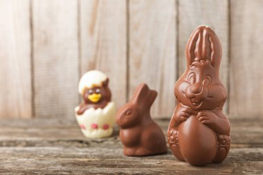 Arka planda paskalya çikolatalı yumurtası. Paskalya kutlaması. Paskalya çikolatalı tavşan. Çikolatalı tatlı yumurta. Şekerler ahşap masanın üzerinde. Mesaj için boşluk. Boşluğu kopyala. Hediye. Pankart.