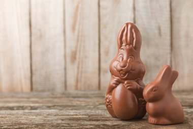 Arka planda paskalya çikolatalı yumurtası. Paskalya kutlaması. Paskalya çikolatalı tavşan. Çikolatalı tatlı yumurta. Şekerler ahşap masanın üzerinde. Mesaj için boşluk. Boşluğu kopyala. Hediye. Pankart.