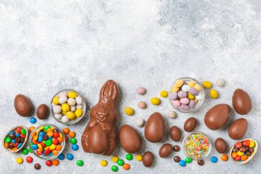 Arka planda paskalya çikolatalı yumurtası. Paskalya kutlaması. Paskalya çikolatalı tavşan. Çikolatalı tatlı yumurta. Şekerler ahşap masanın üzerinde. Mesaj için boşluk. Boşluğu kopyala. Hediye. Pankart.