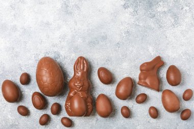 Arka planda paskalya çikolatalı yumurtası. Paskalya kutlaması. Paskalya çikolatalı tavşan. Çikolatalı tatlı yumurta. Şekerler ahşap masanın üzerinde. Mesaj için boşluk. Boşluğu kopyala. Hediye. Pankart.