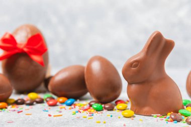 Arka planda paskalya çikolatalı yumurtası. Paskalya kutlaması. Paskalya çikolatalı tavşan. Çikolatalı tatlı yumurta. Şekerler ahşap masanın üzerinde. Mesaj için boşluk. Boşluğu kopyala. Hediye. Pankart.